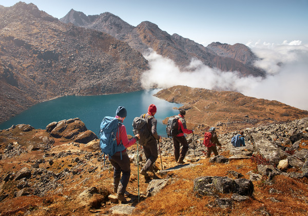 Grupo de turistas com mochilas desce trilha no Parque Nacional Langtang, no Nepal. 
