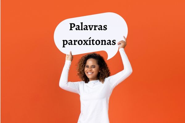 Jovem segurando um balão de diálogo com o escrito “palavras paroxítonas”.