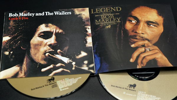 Capas de dois discos de Bob Marley & The Wailers com o rosto do cantor; em uma delas, ele está fumando.
