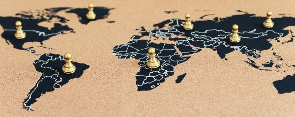 Peões de xadrez sobre países do mapa-múndi em alusão à Nova Ordem Mundial.