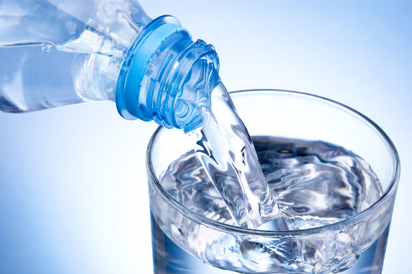 Água mineral, um tipo de solvente, sendo derramada em copo.