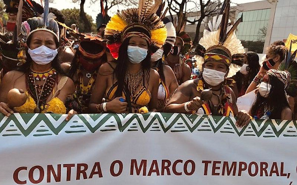 Indígenas protestando contra o marco temporal, medida jurídica utilizada na demarcação de terras indígenas no Brasil. 