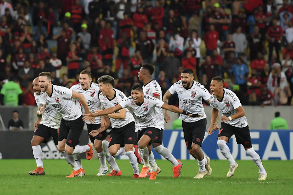 Jogadores do Atlético Paranaense comemorando em campo de futebol.