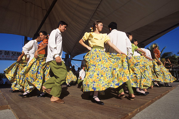 Homens e mulheres dançando fandango, uma das danças folclóricas que existem no Brasil.