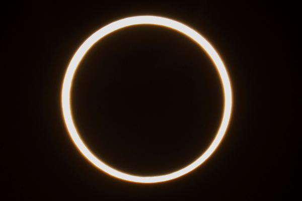 Eclipse solar anular (ou anelar), que aparece como um disco escuro sobre outro maior e brilhante.