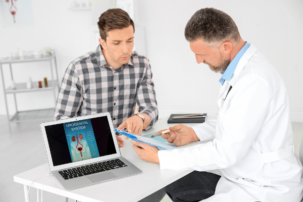 Homem conversando com o médico urologista em um consultório, uma forma de diagnosticar a fimose.