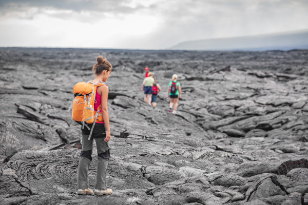 Pessoas caminhando entre as rochas vulcânicas recém-formadas no Parque Nacional dos Vulcões do Havaí, na ilha Grande.