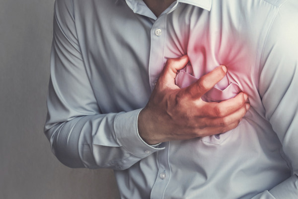 Homem com dor no peito, um dos principais sintomas do mal súbito, muitas vezes associado a problemas cardíacos.