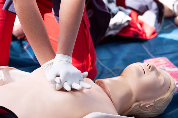 Pessoa treinando reanimação cardíaca em um boneco, medida que pode ajudar em casos de mal súbito.