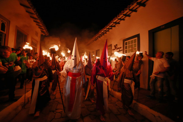 Participantes da Procissão do Fogaréu vestidos a caráter e andando pelas ruas da Cidade de Goiás.