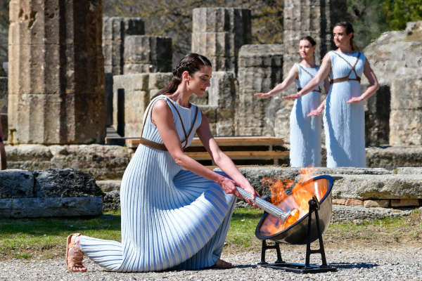 Foto de mulheres gregas acendendo a tocha olímpica.
