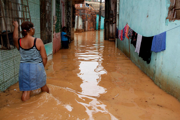 Moradores em bairro alagado durante enchente provocada pelas mudanças climáticas, uma consequência do aquecimento global.