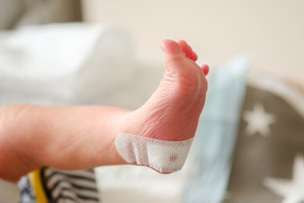Imagem aproximada do pé de um recém-nascido que acabou de realizar o teste do pezinho.