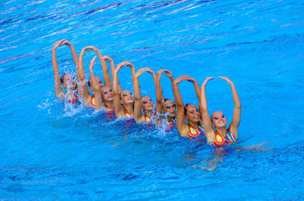 Atletas praticando nado artístico de forma perfeitamente sicronizada.