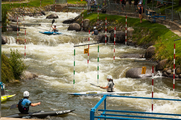 Disputa de canoagem slalom em uma corredeira.