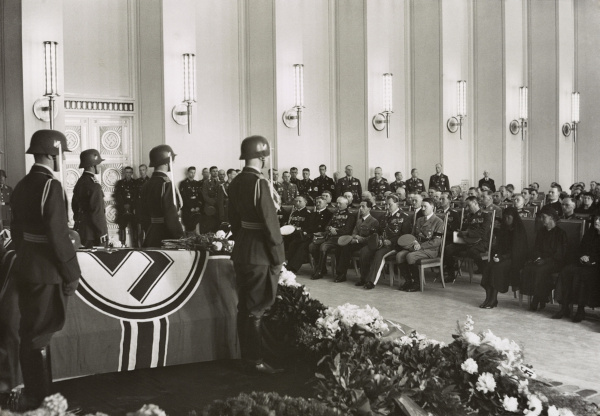 Joseph Goebbels sentado próximo a Adolf Hitler em um funeral nazista.