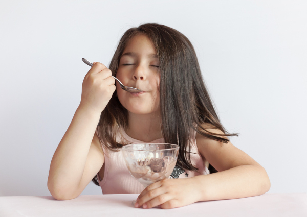 Criança comendo um sorvete caseiro, uma dica de atividade para o Dia das Crianças.