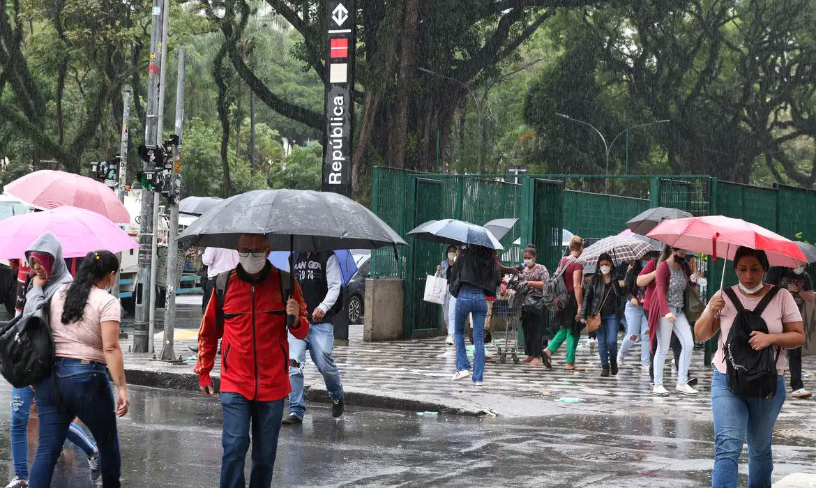 Pessoas na rua durante chuva