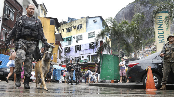 Policiais armados na Rocinha, no Rio de Janeiro, representando a violência externa que contribui para a violência escolar.