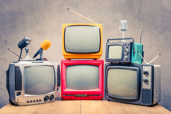 Televisores antigos e microfones em referência à indústria cultural, foco de estudo da Escola de Frankfurt. [imagem principal]