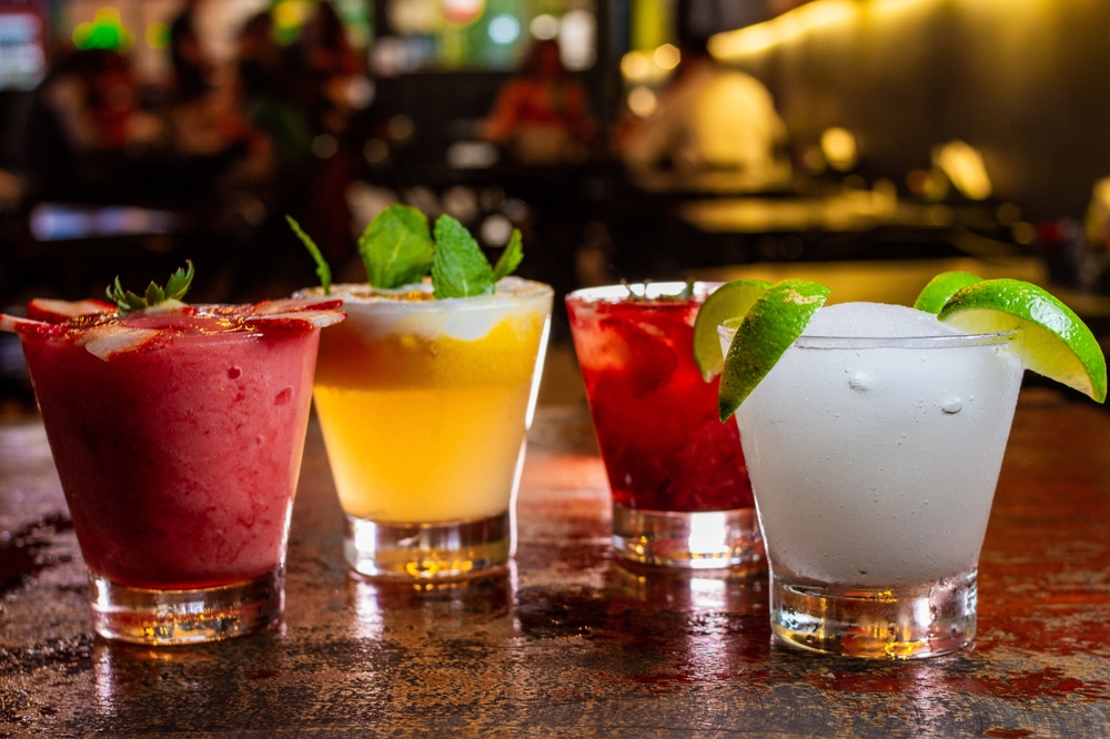 Copo com três coquetéis alcoólicos, exemplos de bebida alcoólica.