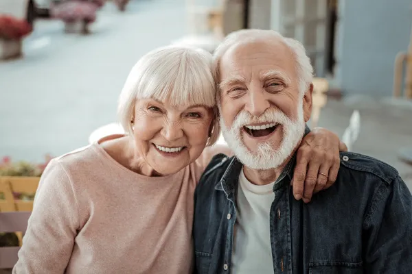 Idosos abraçados e sorrindo