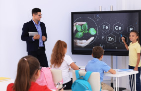 Aula sem laboratório alunos sentados em carteiras e professor a frente da sala