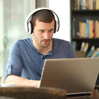 homem usando notebook e com fone de ouvido
