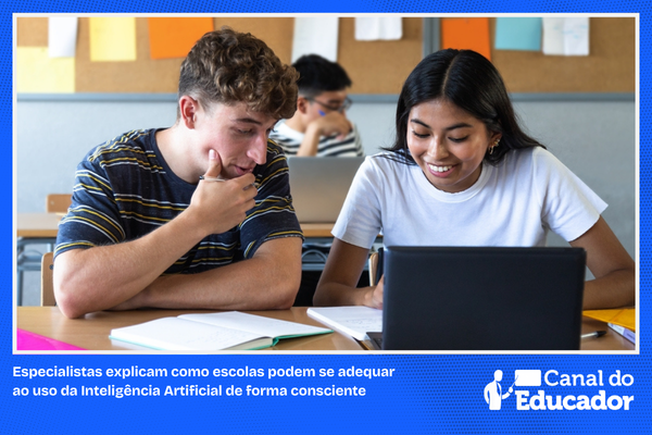 Dois estudnaotes em sala de aula com computador.