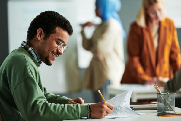 Estudante homem escrevendo em alusão à comprovação de informações do ProUni 2024/2.