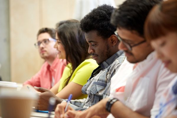 Jovens estudantes realizando prova em referência a declaração de comparecimento no Enem 2024.