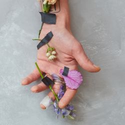 mão humana enfeitada com flores