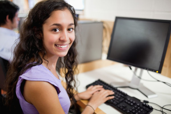 Estudante no computador sorrindo