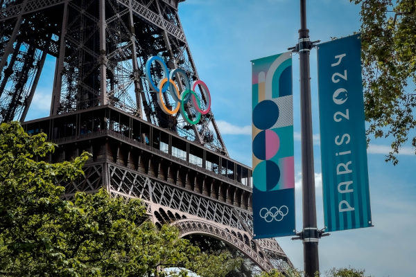 Torre Eiffel e bandeira com logomarca das Olimpíadas de Paris 2024